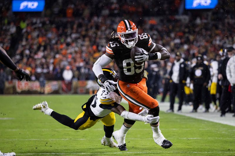 Cleveland Browns tight end David Njoku (85) attempts to break free from Pittsburgh Steelers safety DeShon Elliott (25) during an NFL football game, Thursday, Nov. 21, 2024, in Cleveland. (AP Photo/Matt Durisko)