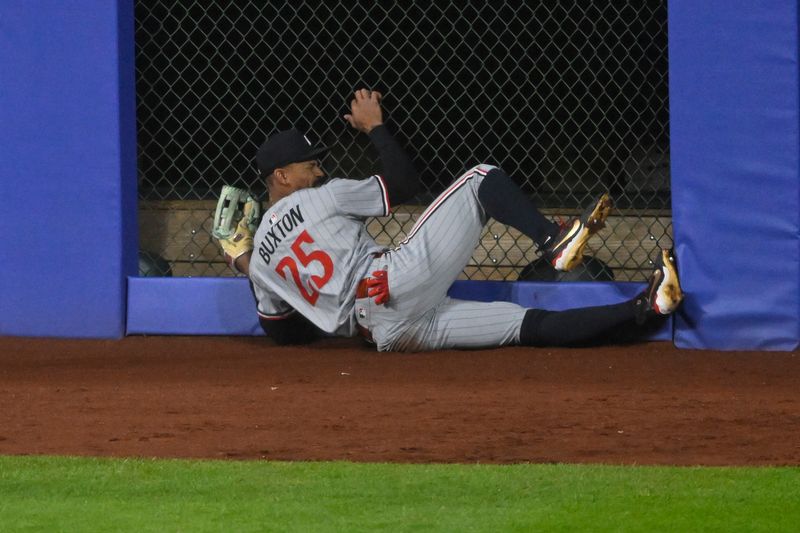 Apr 29, 2025; Cleveland, Ohio, USA; Minnesota Twins center fielder Byron Buxton (25) makes contact with the outfield wall after making a sliding catch in the third inning against the Cleveland Guardians at Progressive Field. Mandatory Credit: David Richard-Imagn Images
