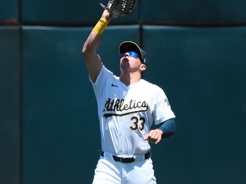 May 23, 2024; Oakland, California, USA; Oakland Athletics center fielder JJ Bleday (33) catches the ball against the Colorado Rockies during the third inning at Oakland-Alameda County Coliseum. Mandatory Credit: Kelley L Cox-USA TODAY Sports