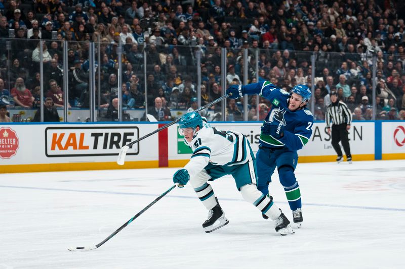 Dec 27, 2025; Vancouver, British Columbia, CAN; Vancouver Canucks defenseman Zeev Buium (24) battles with San Jose Sharks forward Collin Graf (51) in the third period at Rogers Arena. Mandatory Credit: Bob Frid-Imagn Images