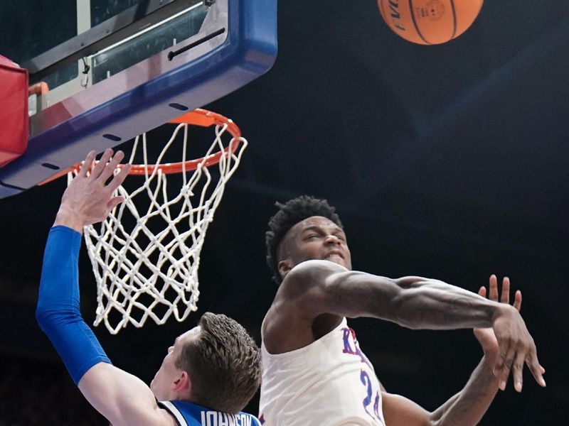 Feb 27, 2024; Lawrence, Kansas, USA; Kansas Jayhawks forward K.J. Adams Jr. (24) blocks a shot by Brigham Young Cougars guard Spencer Johnson (20) during the first half at Allen Fieldhouse. Mandatory Credit: Denny Medley-USA TODAY Sports