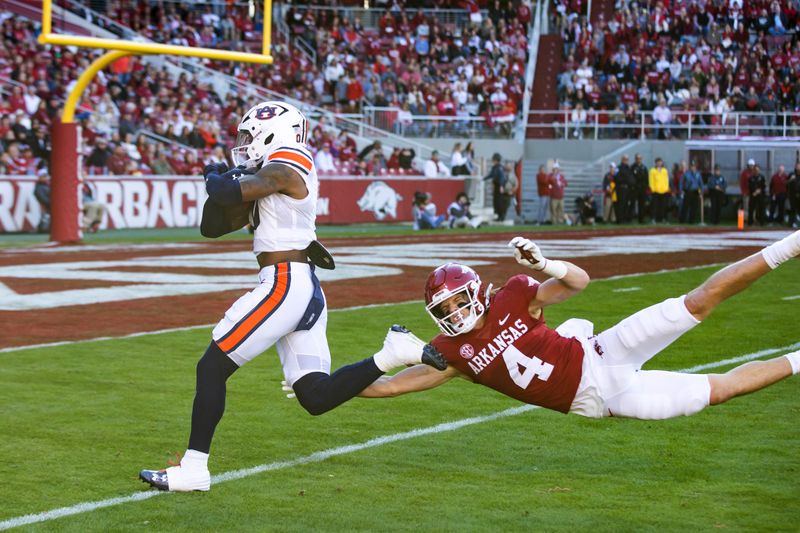 Nov 11, 2023; Fayetteville, Arkansas, USA;  Arkansas Razorbacks wide receiver Isaac TeSlaa (4) attempts to tackle Auburn Tigers cornerback Keionte Scott (0) as he runs a punt back for a touchdown during the first quarter at Donald W. Reynolds Razorback Stadium. Auburn won 48-10. Mandatory Credit: Brett Rojo-USA TODAY Sports