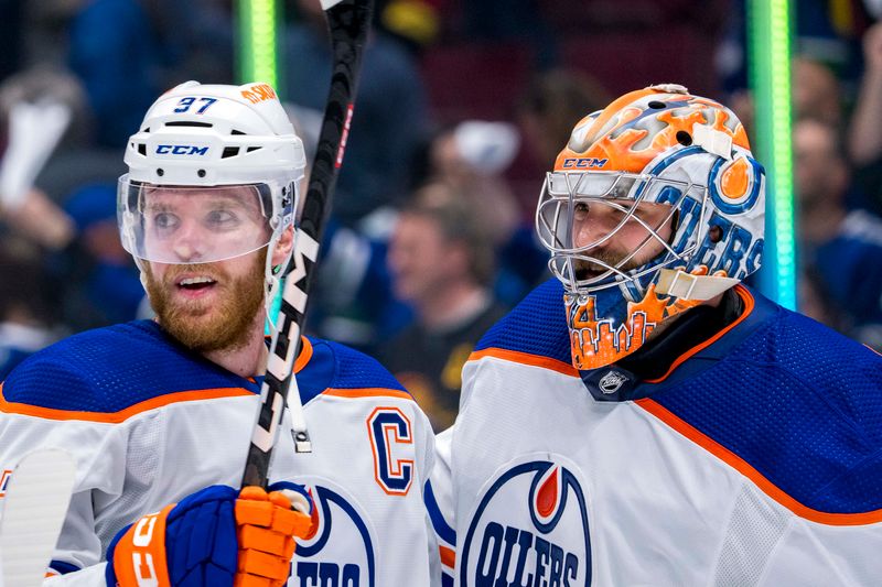 May 20, 2024; Vancouver, British Columbia, CAN; Edmonton Oilers forward Connor McDavid (97) and goalie Stuart Skinner (74) celebrate their victory over the Vancouver Canucks in game seven of the second round of the 2024 Stanley Cup Playoffs at Rogers Arena. Mandatory Credit: Bob Frid-USA TODAY Sports