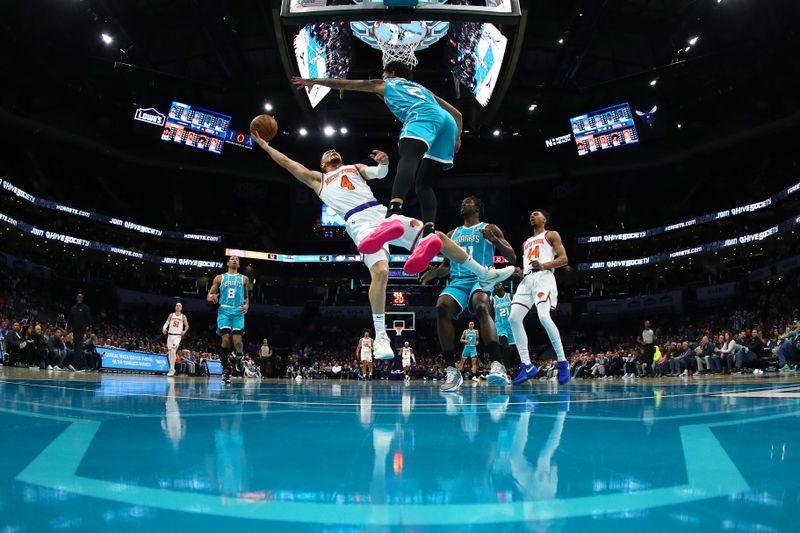 CHARLOTTE, NORTH CAROLINA - JANUARY 29: Duane Washington Jr. #4 of the New York Knicks attempts a lay up against James Bouknight #2 of the Charlotte Hornets during the second half of the game at Spectrum Center on January 29, 2024 in Charlotte, North Carolina. NOTE TO USER: User expressly acknowledges and agrees that, by downloading and or using this photograph, User is consenting to the terms and conditions of the Getty Images License Agreement. (Photo by Jared C. Tilton/Getty Images)