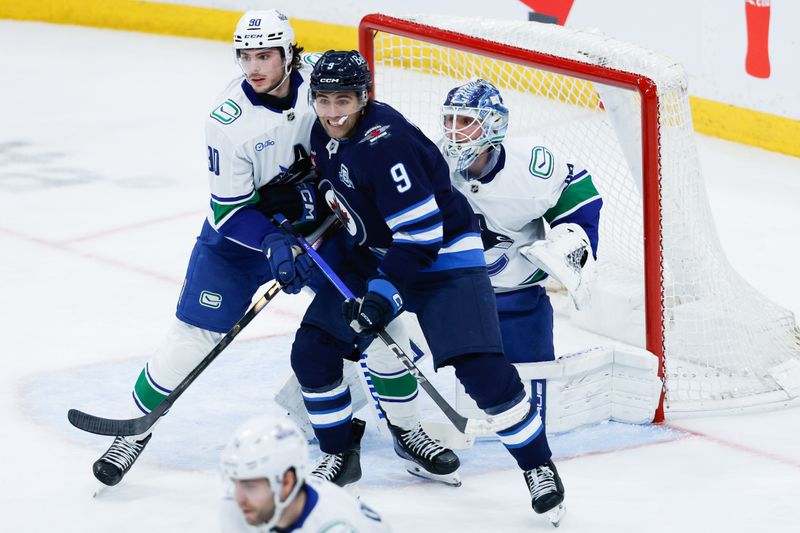 Mar 7, 2026; Winnipeg, Manitoba, CAN;  Winnipeg Jets forward Alex Iafallo (9) jostles for position with Vancouver Canucks defenseman Victor Mancini (90) during the second period at Canada Life Centre. Mandatory Credit: Terrence Lee-Imagn Images