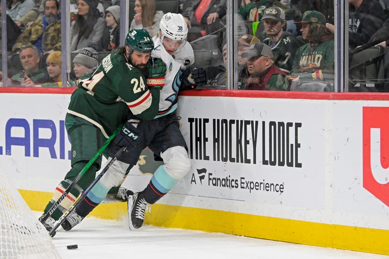 Mar 19, 2025; Saint Paul, Minnesota, USA;  Minnesota Wild defenseman Zach Bogosian (24) bumps Seattle Kraken forward Jani Nyman (38) off of the puck during the third period at Xcel Energy Center. Mandatory Credit: Nick Wosika-Imagn Images