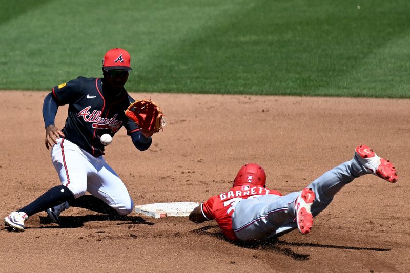 Mar 14, 2025; North Port, Florida, USA;  Washington Nationals second baseman Luis Garcia (2) slides past Atlanta Braves second baseman Ozzie Albies (1) in the fourth inning during spring training at CoolToday Park. Mandatory Credit: Jonathan Dyer-Imagn Images