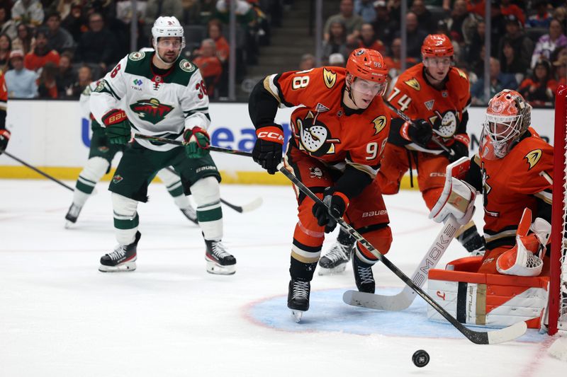 Jan 2, 2026; Anaheim, California, USA;  Anaheim Ducks defenseman Pavel Mintyukov (98) clears the puck as goaltender Lukas Dostal (1) defends the goal during the third period against the Minnesota Wild at Honda Center. Mandatory Credit: Kiyoshi Mio-Imagn Images