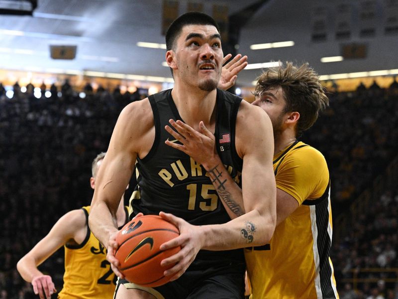 Jan 20, 2024; Iowa City, Iowa, USA; Purdue Boilermakers center Zach Edey (15) goes to the basket as Iowa Hawkeyes forward Owen Freeman (32) defends and forward Payton Sandfort (20) looks on during the first half at Carver-Hawkeye Arena. Mandatory Credit: Jeffrey Becker-USA TODAY Sports