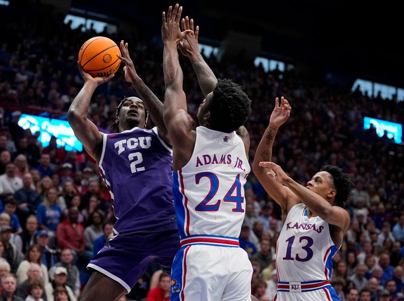 Jan 6, 2024; Lawrence, Kansas, USA; TCU Horned Frogs forward Emanuel Miller (2) shoots against Kansas Jayhawks forward K.J. Adams Jr. (24) and guard Elmarko Jackson (13) during the first half at Allen Fieldhouse. Mandatory Credit: Jay Biggerstaff-USA TODAY Sports