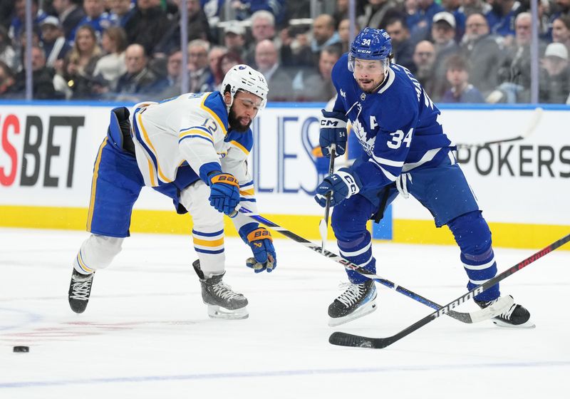 Mar 6, 2024; Toronto, Ontario, CAN; Toronto Maple Leafs center Auston Matthews (34) battles for the puck with Buffalo Sabres left wing Jordan Greenway (12) during the first period at Scotiabank Arena. Mandatory Credit: Nick Turchiaro-USA TODAY Sports