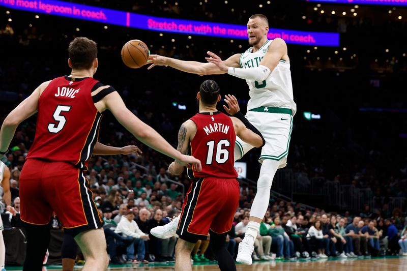 BOSTON, MA - APRIL 21: Kristaps Porzingis #8 of the Boston Celtics passes past Caleb Martin #16 of the Miami Heat during the second half of game one of the Eastern Conference First Round Playoffs at TD Garden on April 21, 2024 in Boston, Massachusetts. NOTE TO USER: User expressly acknowledges and agrees that, by downloading and/or using this Photograph, user is consenting to the terms and conditions of the Getty Images License Agreement. (Photo By Winslow Townson/Getty Images)