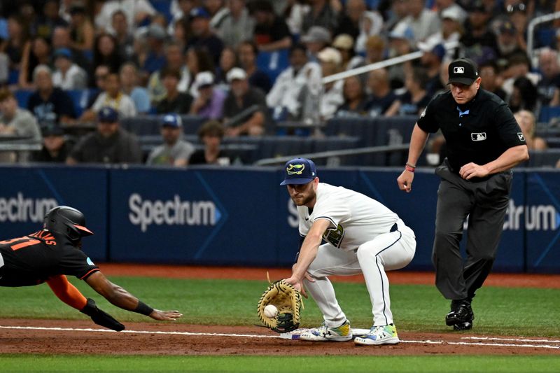 Aug 9, 2024; St. Petersburg, Florida, USA; Baltimore Orioles center fielder Cedric Mullen (31) dives back to first base as Tampa Bay Rays first baseman  Brandon Lowe (8) waits for the ball in the second inning  at Tropicana Field. Mandatory Credit: Jonathan Dyer-USA TODAY Sports