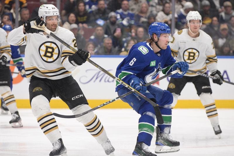 Feb 24, 2024; Vancouver, British Columbia, CAN;  Boston Bruins defenseman Derek Forbort (28) defends against Vancouver Canucks forward Brock Boeser (6) during the third period at Rogers Arena. Mandatory Credit: Anne-Marie Sorvin-USA TODAY Sports