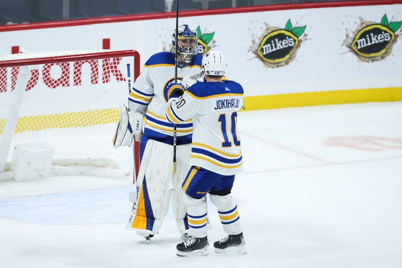 Jan 26, 2023; Winnipeg, Manitoba, CAN;  Buffalo Sabres goalie Eric Comrie (31) is congratulated by Buffalo Sabres defenseman Henri Jokiharju (10) on his win against the Winnipeg Jets at the end of the third period at Canada Life Centre. Mandatory Credit: Terrence Lee-USA TODAY Sports