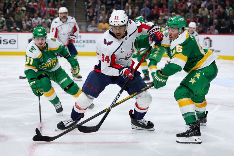 Dec 16, 2025; Saint Paul, Minnesota, USA; Washington Capitals right wing Justin Sourdif (34) and Minnesota Wild defenseman Jared Spurgeon (46) compete for the puck during the third period at Grand Casino Arena. Mandatory Credit: Matt Krohn-Imagn Images