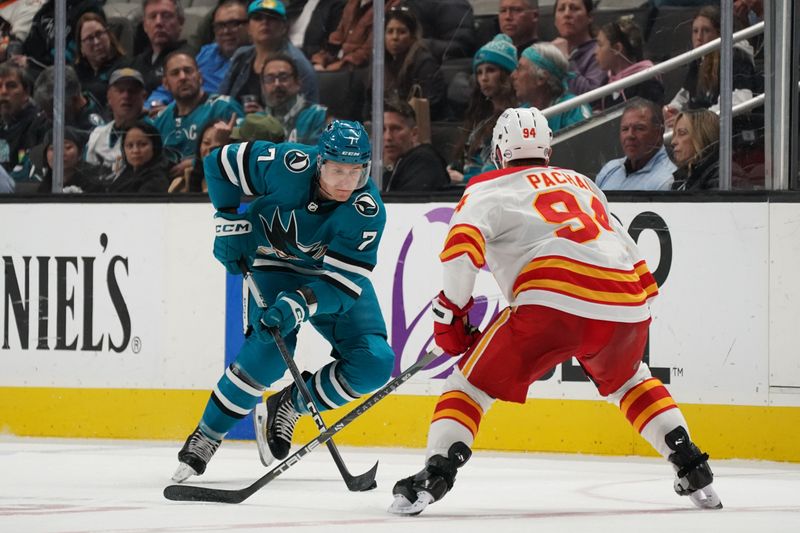 Apr 9, 2024; San Jose, California, USA; San Jose Sharks center Nico Sturm (7) advances the puck against Calgary Flames defenseman Brayden Pachal (94) during the second period at SAP Center at San Jose. Mandatory Credit: David Gonzales-USA TODAY Sports