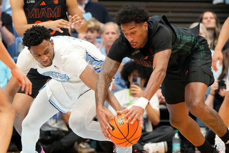 Mar 1, 2025; Chapel Hill, North Carolina, USA;  North Carolina Tar Heels forward Jalen Washington (13) and Miami (Fl) Hurricanes forward Brandon Johnson (2) fight for the ball in the first half at Dean E. Smith Center. Mandatory Credit: Bob Donnan-Imagn Images