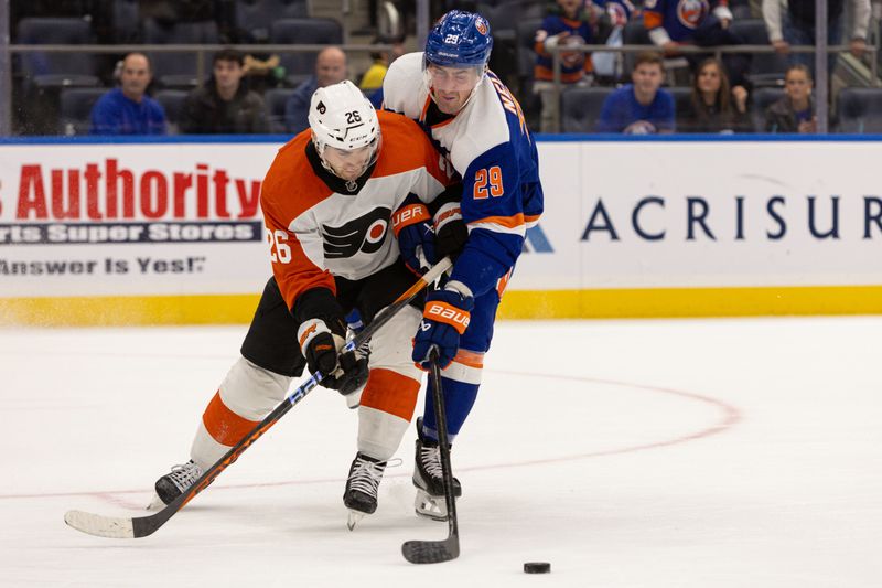 Nov 25, 2023; Elmont, New York, USA; Philadelphia Flyers defenseman Sean Walker (26) and New York Islanders center Brock Nelson (29) fight for the puck during overtime at UBS Arena. Mandatory Credit: Thomas Salus-USA TODAY Sports