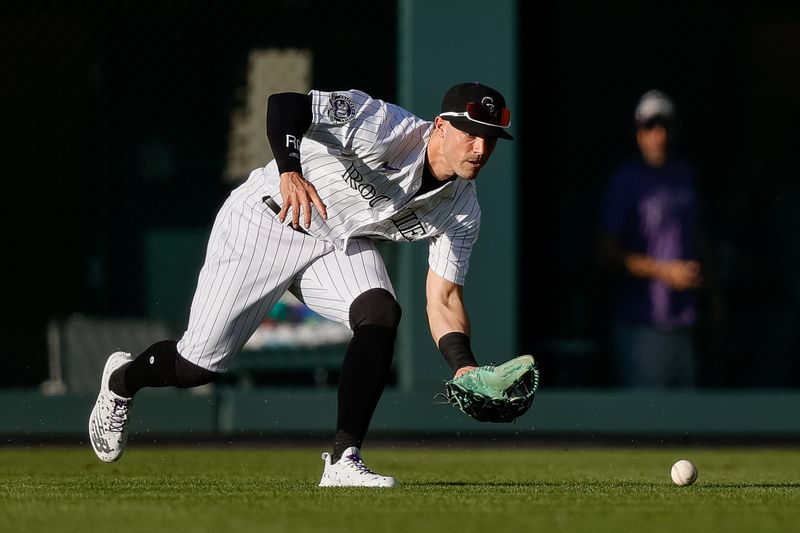 Jul 28, 2023; Denver, Colorado, USA; Colorado Rockies right fielder Randal Grichuk (15) fields the ball in the first inning against the Oakland Athletics at Coors Field. Mandatory Credit: Isaiah J. Downing-USA TODAY Sports