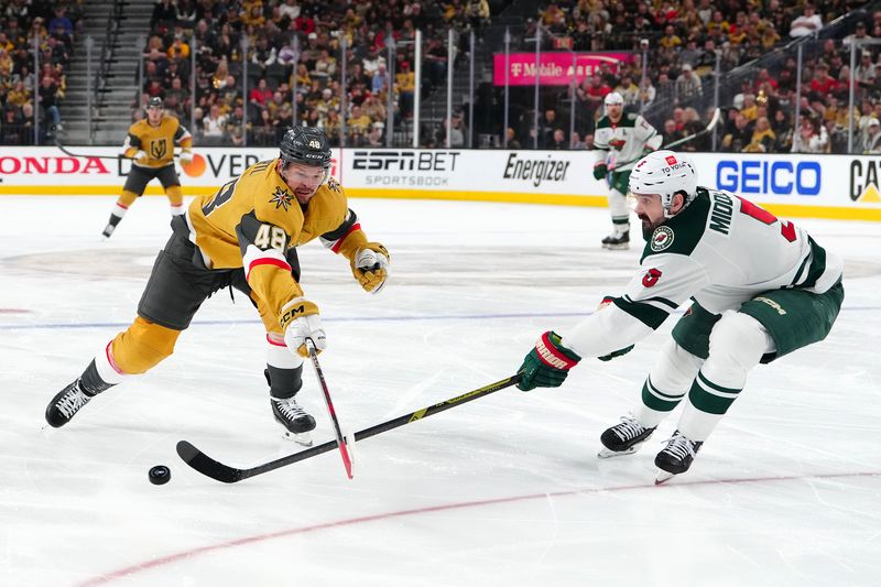 Apr 29, 2025; Las Vegas, Nevada, USA; Minnesota Wild defenseman Jake Middleton (5) chips the puck away from Vegas Golden Knights center Tomas Hertl (48) during the second period of game five of the first round of the 2025 Stanley Cup Playoffs at T-Mobile Arena. Mandatory Credit: Stephen R. Sylvanie-Imagn Images