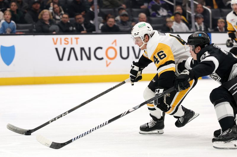 Jan 20, 2025; Los Angeles, California, USA;  Pittsburgh Penguins center Blake Lizotte (46) skates with the puck ahead of Los Angeles Kings defenseman Jordan Spence (21) during the third period at Crypto.com Arena. Mandatory Credit: Kiyoshi Mio-Imagn Images