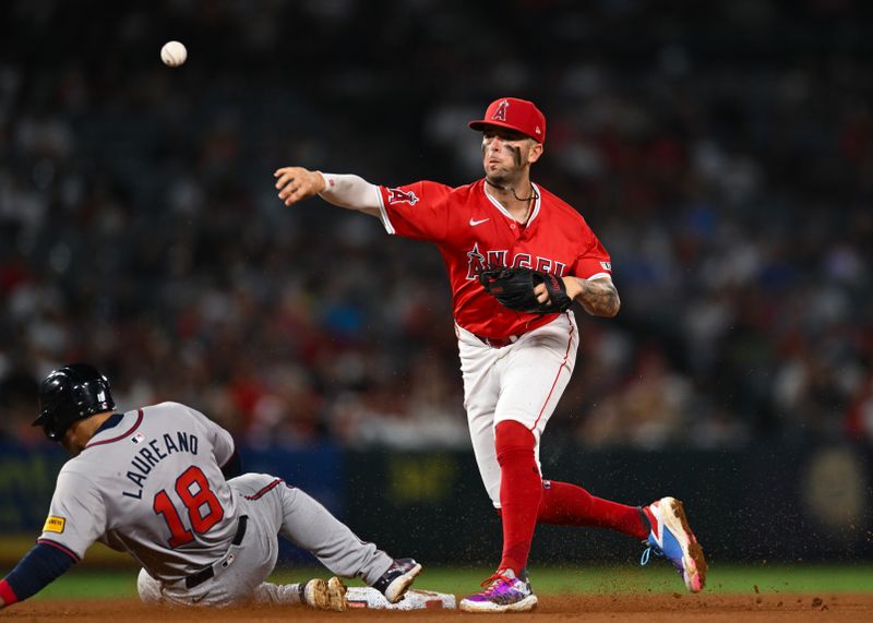 Aug 17, 2024; Anaheim, California, USA; Los Angeles Angels shortstop Zach Neto (9) makes a catch against Atlanta Braves outfielder Ramon Laureano (18) during the seventh inning at Angel Stadium. Mandatory Credit: Jonathan Hui-USA TODAY Sports