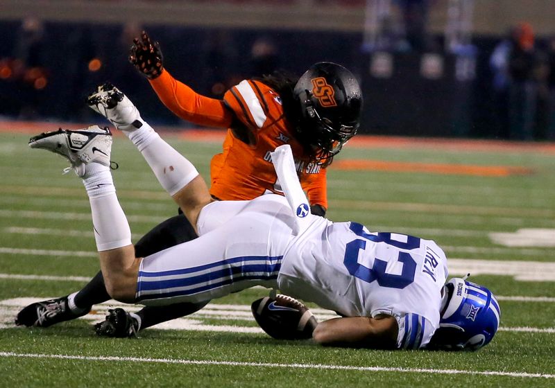 Nov 25, 2023; Stillwater, Oklahoma, USA; Oklahoma State's Trey Rucker (9) forces Isaac Rex (83) to fumble the ball  during the second overtime  at Boone Pickens Stadium. Mandatory Credit: Sarah Phipps-USA TODAY Sports