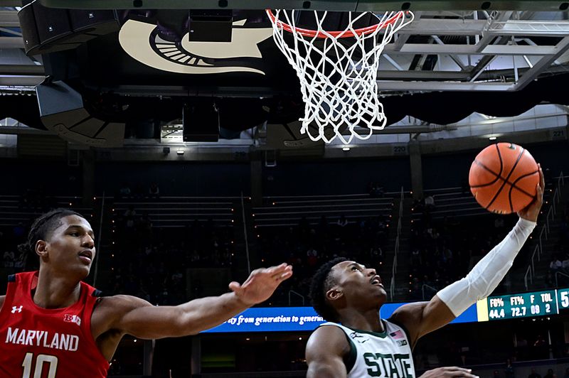 Feb 7, 2023; East Lansing, Michigan, USA;  Michigan State Spartans guard Tyson Walker (2) drives past Maryland Terrapins forward Julian Reese (10) for a second half layup at Jack Breslin Student Events Center. Mandatory Credit: Dale Young-USA TODAY Sports