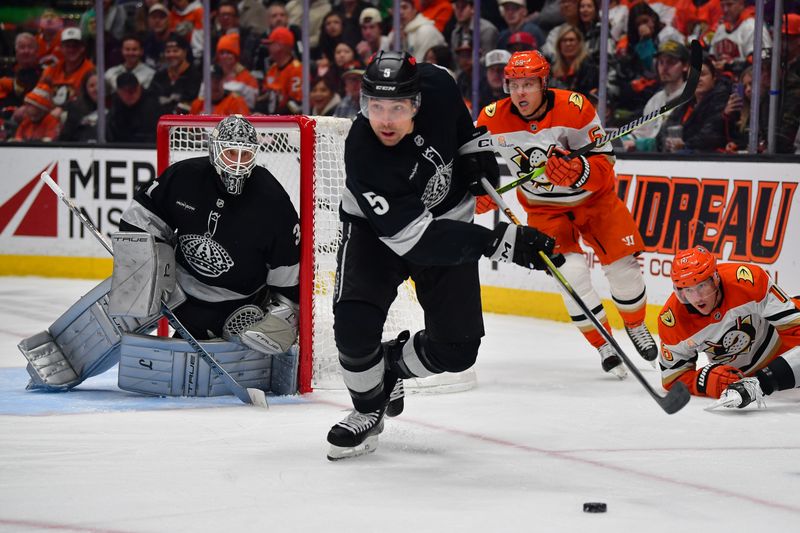 Jan 17, 2026; Anaheim, California, USA; Los Angeles Kings defenseman Cody Ceci (5) gets the puck ahead of Anaheim Ducks center Mikael Granlund (64) and center Ryan Strome (16) during the second period at Honda Center. Mandatory Credit: Gary A. Vasquez-Imagn Images