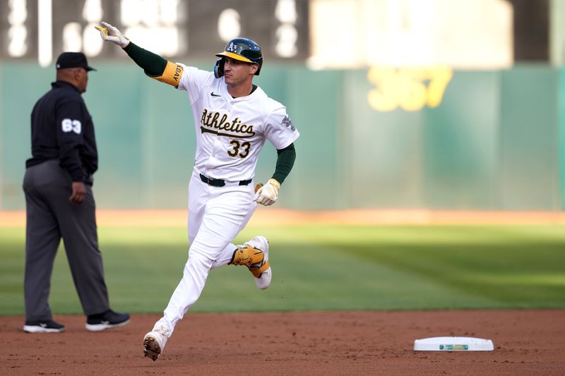 Aug 21, 2024; Oakland, California, USA; Oakland Athletics center fielder JJ Bleday (33) gestures while rounding the bases after hitting a home run against the Tampa Bay Rays during the first inning at Oakland-Alameda County Coliseum. Mandatory Credit: Darren Yamashita-USA TODAY Sports