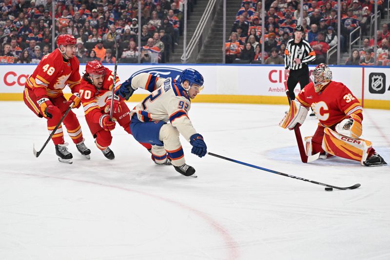 Dec 23, 2025; Edmonton, Alberta, CAN;  Calgary Flames defenseman Hunterv Brzustewicz (48) with Flames left winger Ryan Lomberg (70) chase Edmonton Oilers right winger Vasily Podkolzin (92) as he goes toward Flames goalie Dustin Wolf (32) during the first period at Rogers Place. Mandatory Credit: Walter Tychnowicz-Imagn Images