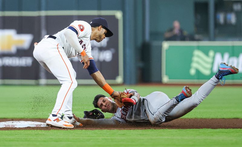 May 1, 2024; Houston, Texas, USA;  Cleveland Guardians shortstop Brayan Rocchio (4) is tagged out by Houston Astros shortstop Jeremy Pena (3) on a play during the third inning at Minute Maid Park. Mandatory Credit: Troy Taormina-USA TODAY Sports