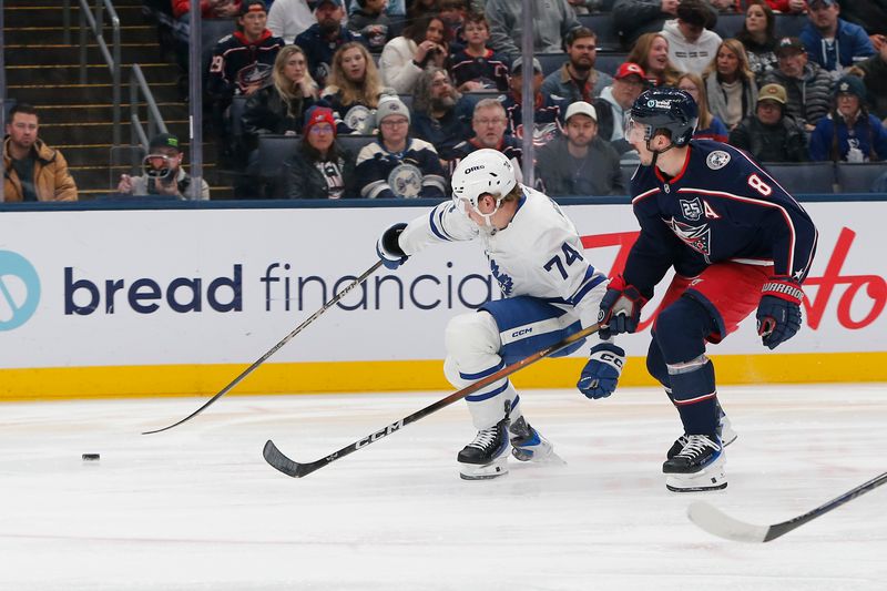 Nov 26, 2025; Columbus, Ohio, USA; Toronto Maple Leafs center Bobby McMann (74) loses control of the puck as Columbus Blue Jackets defenseman Zach Werenski (8) defends during the first period at Nationwide Arena. Mandatory Credit: Russell LaBounty-Imagn Images