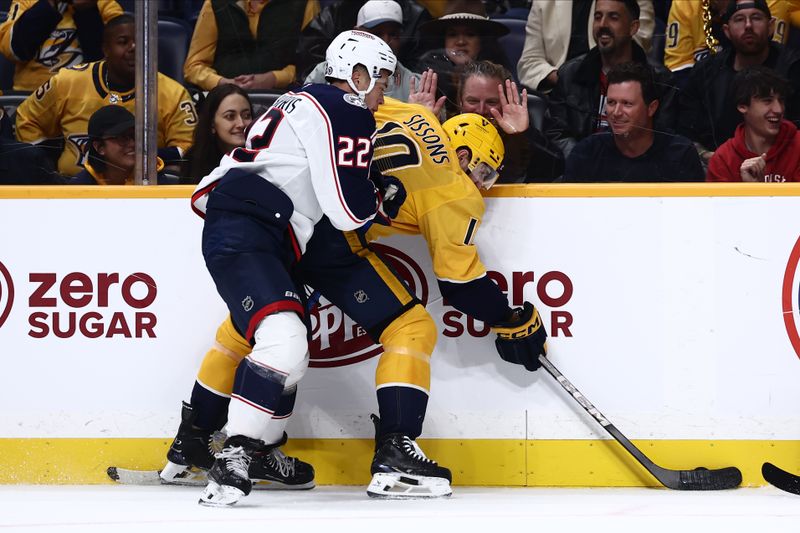 Oct 26, 2024; Nashville, Tennessee, USA; Nashville Predators center Colton Sissons (10) holds a puck against the boards away from Columbus Blue Jackets defenseman Jordan Harris (22) in the first period at Bridgestone Arena. Mandatory Credit: Casey Gower-Imagn Images