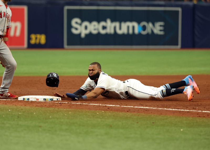 Sep 21, 2023; St. Petersburg, Florida, USA; Tampa Bay Rays center fielder Manuel Margot (13) slides safely into third base during the sixth inning against the Los Angeles Angels at Tropicana Field. Mandatory Credit: Kim Klement Neitzel-USA TODAY Sports