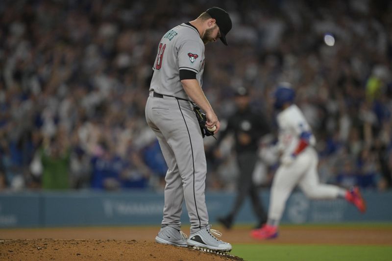May 21, 2025; Los Angeles, California, USA;  Arizona Diamondbacks starting pitcher Corbin Burnes (39) stands on the mound as Los Angeles Dodgers right fielder Teoscar Hernandez (37) rounds the bases after hitting a three-run home run in the sixth inning at Dodger Stadium. Mandatory Credit: Jayne Kamin-Oncea-Imagn Images