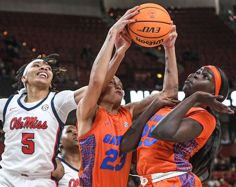 March 8, 2024; Greenville, S.C.; Florida guard Leilani Correa (23) rebounds near teammate  Faith Dut (25), right, and Ole Miss forward Snudda Collins (5) during the first quarter of the SEC Women's Basketball Tournament game at the Bon Secours Wellness Arena in Greenville, S.C. Friday, March 8, 2024. . Mandatory Credit: Ken Ruinard -USA TODAY NETWORK