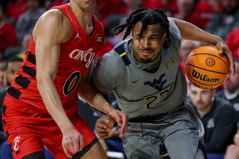 Mar 9, 2024; Cincinnati, Ohio, USA; West Virginia Mountaineers forward Josiah Harris (22) dribbles against Cincinnati Bearcats guard Dan Skillings Jr. (0) in the second half at Fifth Third Arena. Mandatory Credit: Katie Stratman-USA TODAY Sports