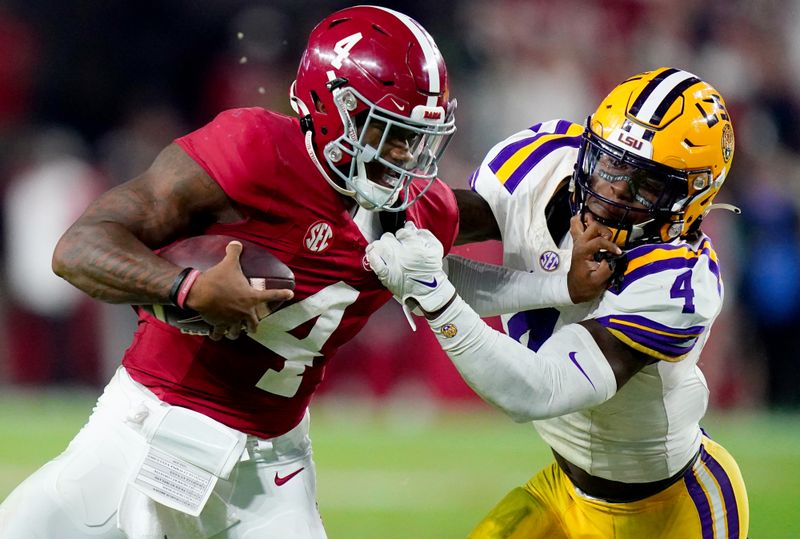 Nov 4, 2023; Tuscaloosa, Alabama, USA; Alabama Crimson Tide quarterback Jalen Milroe (4) scrambles up the field against LSU Tigers linebacker Harold Perkins Jr. (4)  during the second half at Bryant-Denny Stadium. Alabama Crimson Tide defeated the LSU Tigers 42-28. Mandatory Credit: John David Mercer-USA TODAY Sports