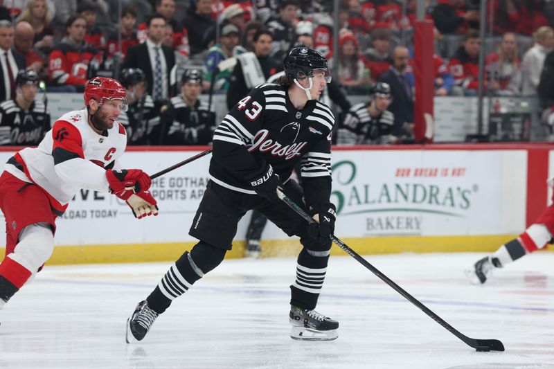 Jan 17, 2026; Newark, New Jersey, USA; New Jersey Devils defenseman Luke Hughes (43) looks to move the puck against the Carolina Hurricanes during the first period at Prudential Center. Mandatory Credit: Thomas Salus-Imagn Images