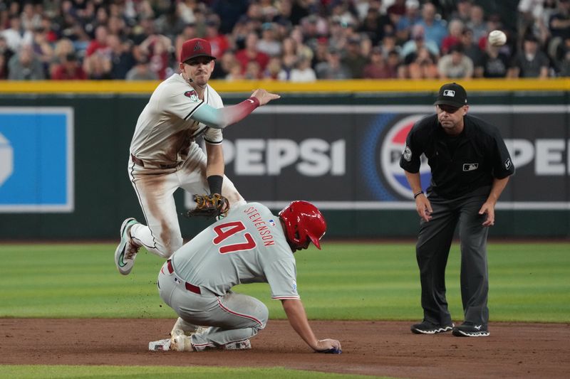 Aug 11, 2024; Phoenix, Arizona, USA; Arizona Diamondbacks shortstop Kevin Newman (18) turns the double play while avoiding Philadelphia Phillies centerfielder Cal Stevenson (47) in the seventh inning at Chase Field. Mandatory Credit: Rick Scuteri-USA TODAY Sports