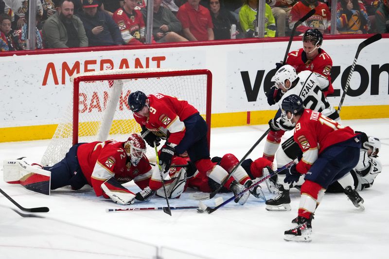 Jan 11, 2024; Sunrise, Florida, USA; Florida Panthers left wing Matthew Tkachuk (19) clears the puck in front of Los Angeles Kings left wing Kevin Fiala (22), center Sam Bennett (9) and goaltender Sergei Bobrovsky (72) during the second period at Amerant Bank Arena. Mandatory Credit: Jasen Vinlove-USA TODAY Sports