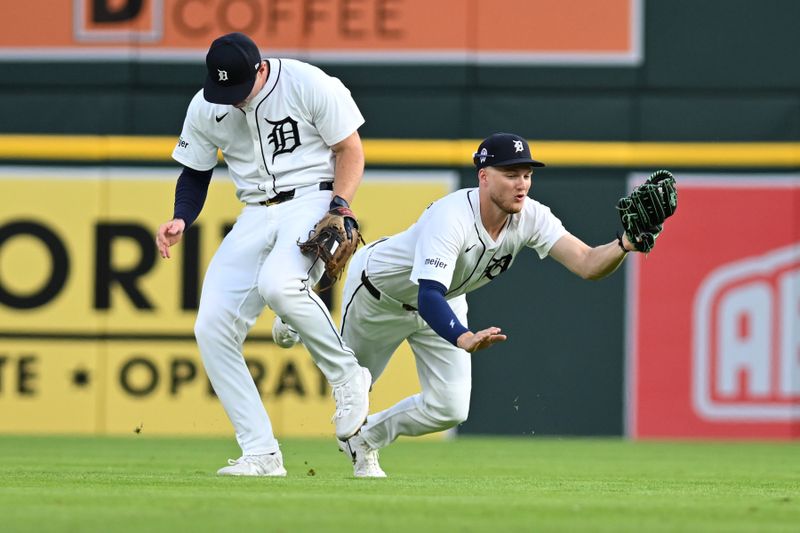 Sep 11, 2024; Detroit, Michigan, USA; Detroit Tigers second baseman Colt Keith (33) ducks out of the way of center fielder Parker Meadows (22) to avoid a collision as Meadows ran in to catch a shallow fly ball behind second base against the Colorado Rockies in the first inning at Comerica Park. Mandatory Credit: Lon Horwedel-Imagn Images