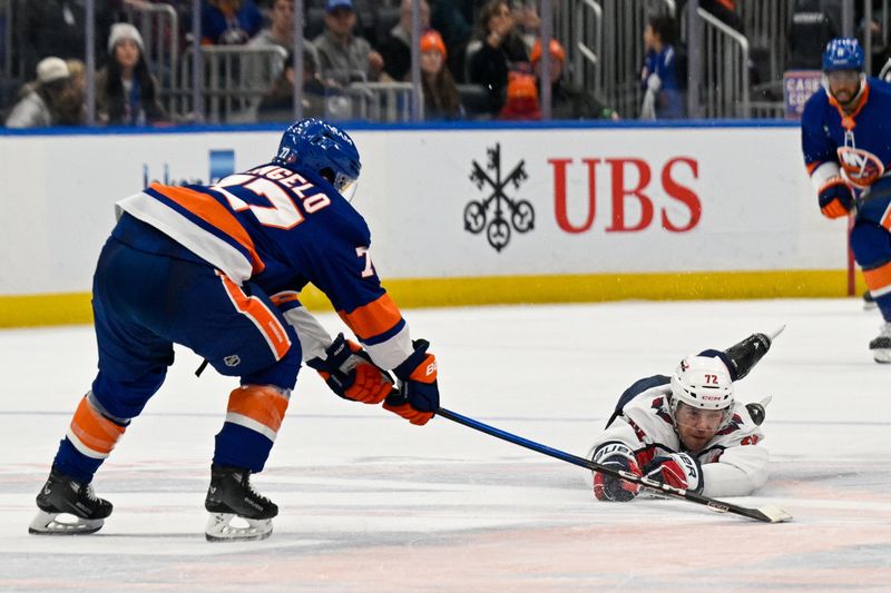 Nov 30, 2025; Elmont, New York, USA;  Washington Capitals left wing Anthony Beauvillier (72) dives for the loose puck controlled by New York Islanders defenseman Tony Deangelo (77) during the third period at UBS Arena. Mandatory Credit: Dennis Schneidler-Imagn Images