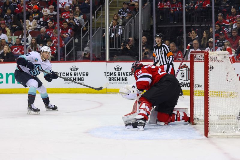 Dec 6, 2024; Newark, New Jersey, USA; Seattle Kraken left wing Andre Burakovsky (95) scores a goal on New Jersey Devils goaltender Jacob Markstrom (25) during the first period at Prudential Center. Mandatory Credit: Ed Mulholland-Imagn Images