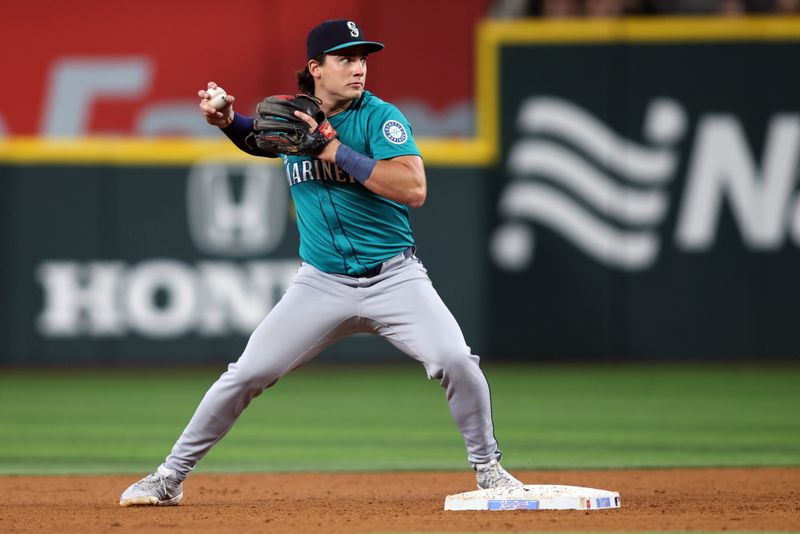 Jun 29, 2025; Arlington, Texas, USA; Seattle Mariners second base Cole Young (2) turns a double play during the fourth inning against the Texas Rangers at Globe Life Field. Mandatory Credit: Tim Heitman-Imagn Images