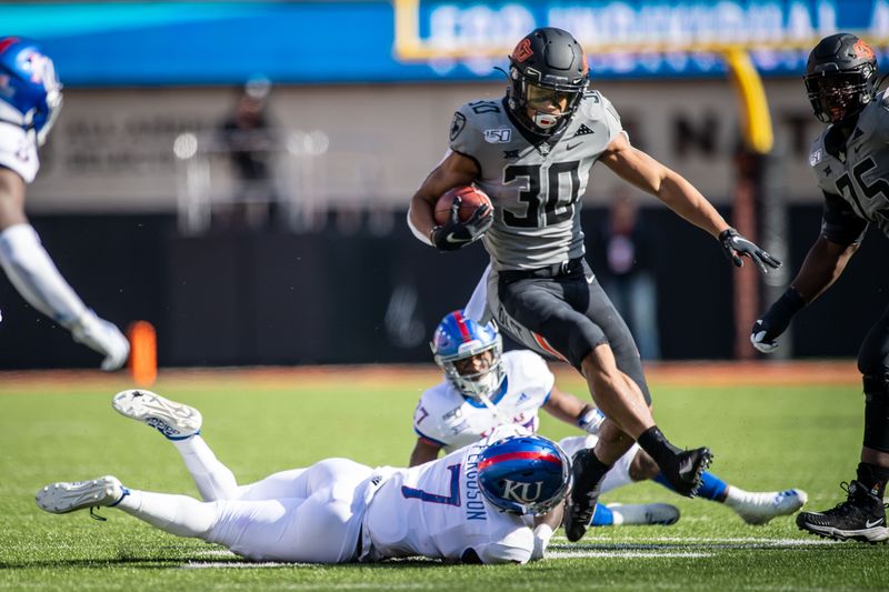 Nov 16, 2019; Stillwater, OK, USA; Oklahoma State Cowboys running back Chuba Hubbard (30) avoids a tackle by Kansas Jayhawks safety Davon Ferguson (7) during the first quarter at Boone Pickens Stadium. Mandatory Credit: Rob Ferguson-USA TODAY Sports