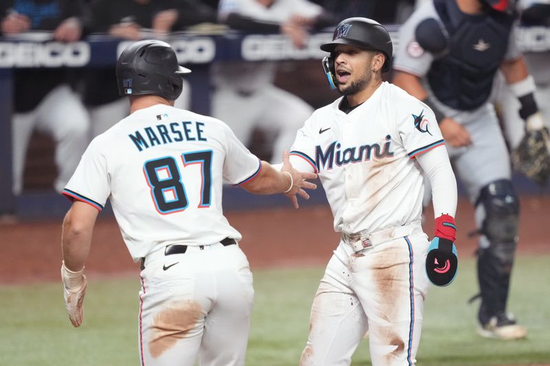 Sep 11, 2025; Miami, Florida, USA;  Miami Marlins center fielder Victor Mesa Jr. (10) celebrates scoring a run with center fielder Jakob Marsee (87) against the Washington Nationals in the eighth inning at loanDepot Park. Mandatory Credit: Jim Rassol-Imagn Images