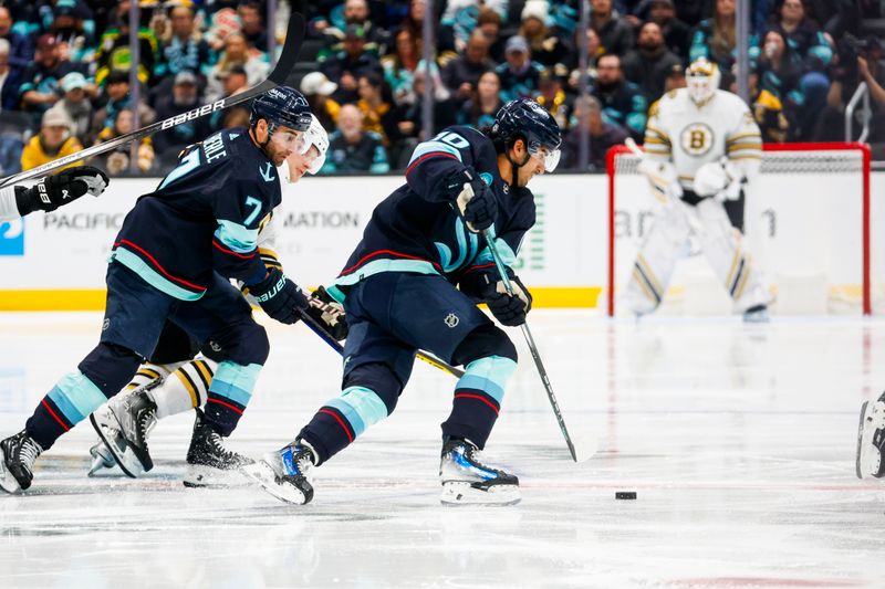 Feb 26, 2024; Seattle, Washington, USA; Seattle Kraken center Matty Beniers (10) skates with the puck next to right wing Jordan Eberle (7) against the Boston Bruins during the second period at Climate Pledge Arena. Mandatory Credit: Joe Nicholson-USA TODAY Sports